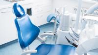 A clean, empty dentist chair in a brightly lit exam room